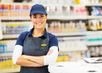 beautiful young female supermarket worker with arms crossed