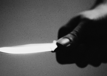 Hand holding knife, close-up, b&w