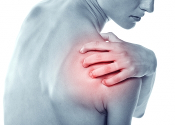 Acute pain in a shoulder at the young women. young girl keeps for a sick shoulder on a white background