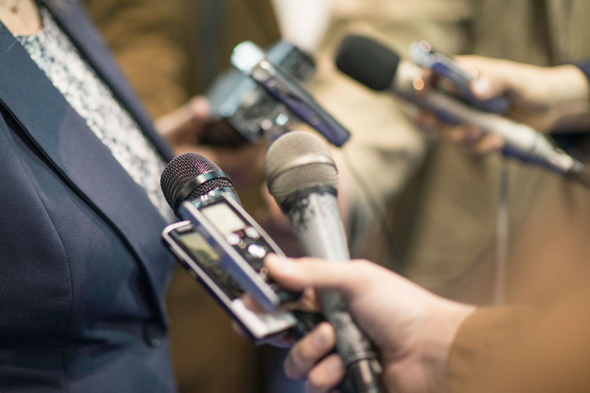 57134905 - group of journalists interviewing politician, holding microphones and voice recorders