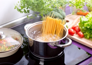 pan of boiling water with spaghetti on the cooker in the kitchen