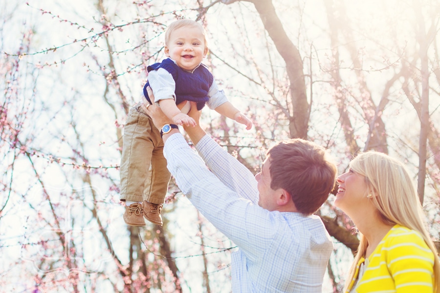 Baby plays outdoors in the fall weather with her family, photographed by portrait photographer Becca Bond