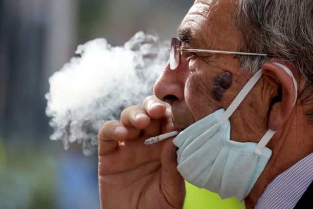 A man wearing a face mask smokes a cigaret, as Albanian authorities  take measures  to stop the spread of the coronavirus disease (COVID-19)  in Tirana, Albania April 6, 2020. REUTERS/Florion Goga