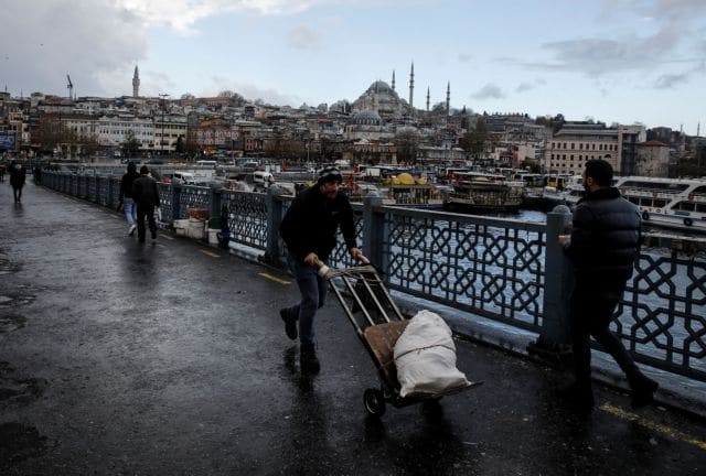 People walk along the Galata Bridge in Istanbul, Turkey, November 30, 2021. REUTERS/Umit Bektas