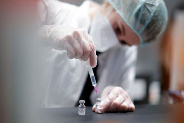 FILE PHOTO: A nurse prepares a shot of "Comirnaty" Pfizer-BioNTech coronavirus disease (COVID-19) vaccine at the vaccination centre in the Humboldt Forum in Berlin, Germany January 19, 2022.  REUTERS/Michele Tantussi/File Photo