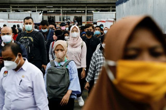 FILE PHOTO: People wearing protective masks walk through a platform of a train station during the afternoon rush hours as the Omicron variant continues to spread, amid the coronavirus disease (COVID-19) pandemic, in Jakarta, Indonesia, January 3, 2022. REUTERS/Willy Kurniawan/File Photo