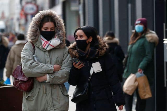 People, wearing protective face masks, walk on a street in Brussels, amid the rise of the coronavirus disease (COVID-19) cases due to the Omicron variant in Belgium, January 21, 2022. REUTERS/ Johanna Geron