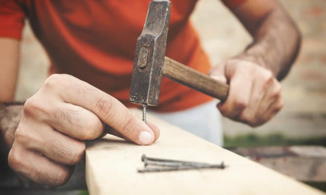 Outdoor portraits of young man cutting painting and repairing wooden boards. Shallow DOF. Developed from RAW; retouched with special care and attention; Small amount of grain added for best final impression. 16 bit Adobe RGB color profile.