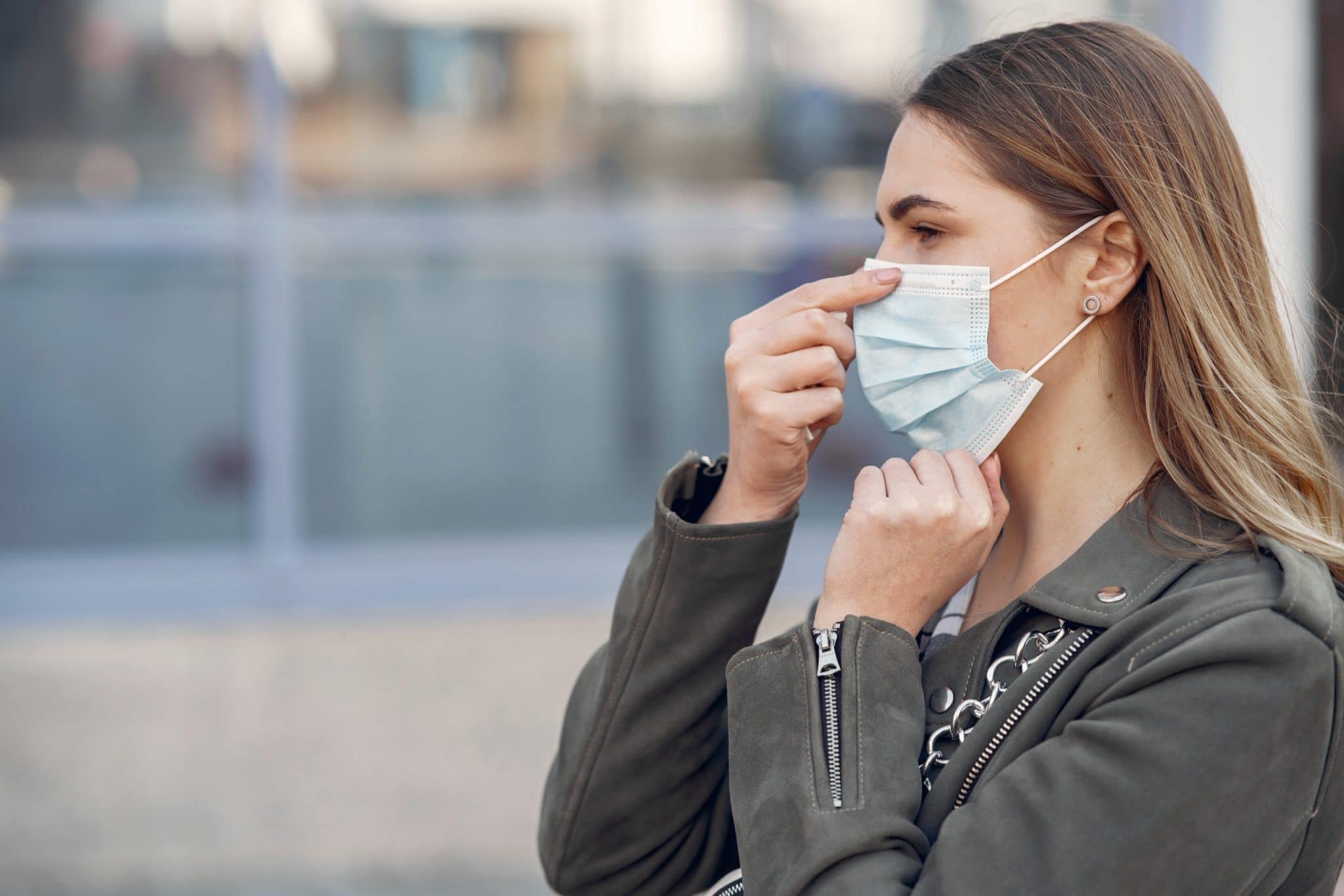 Woman in the city. Person in a mask. Coronavirus theme.