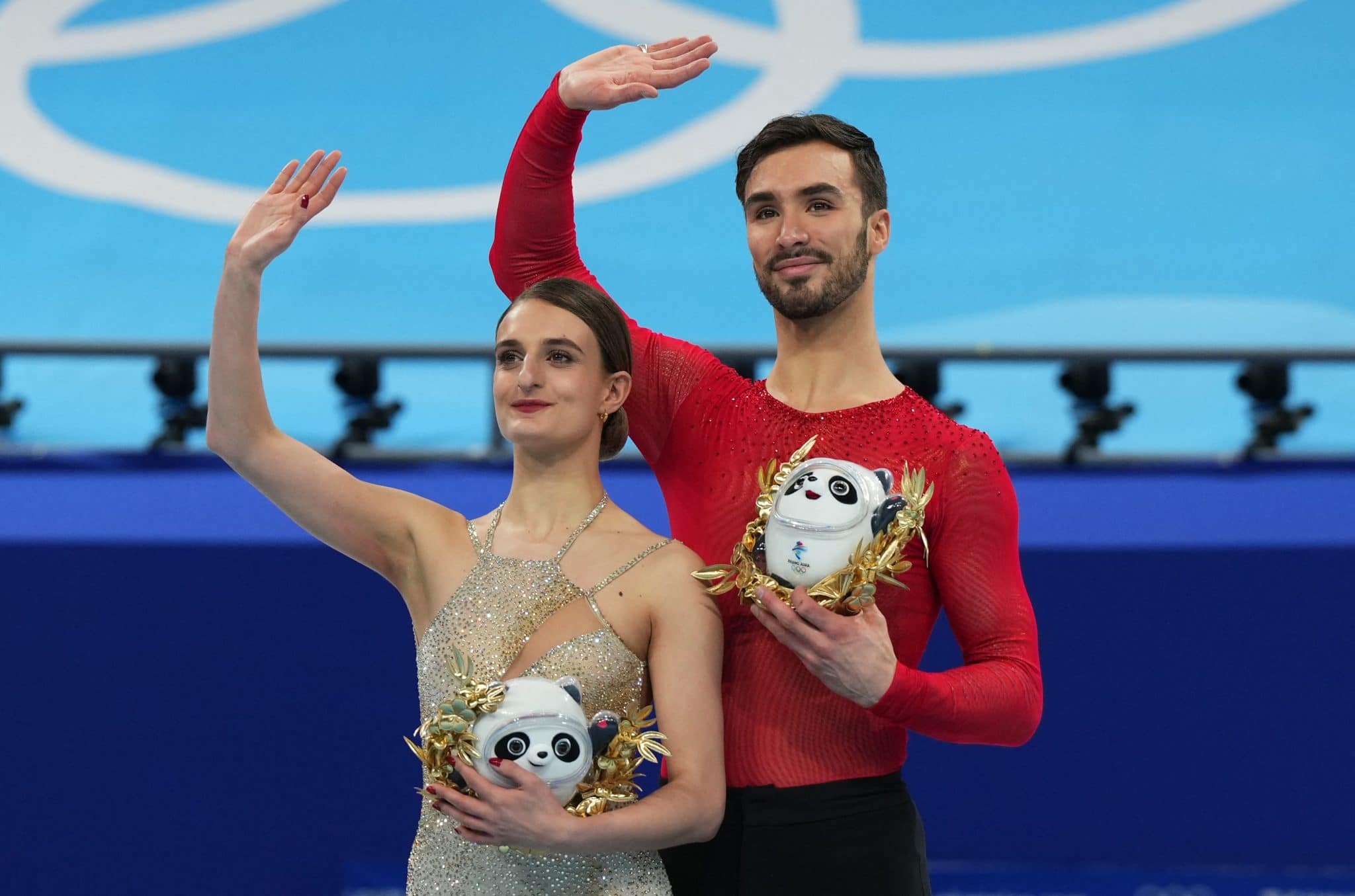 2022 Beijing Olympics - Figure Skating - Ice Dance - Free Dance - Capital Indoor Stadium, Beijing, China - February 14, 2022. Gold medallists Gabriella Papadakis of France and Guillaume Cizeron of France celebrate on the podium with awards depicting Bing Dwen Dwen, the mascot of the Beijing 2022 Winter Olympics during the flower ceremony. REUTERS/Aleksandra Szmigiel