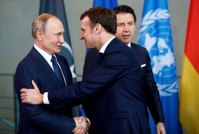 FILE PHOTO: Russian President Vladimir Putin shakes hands with French President Emmanuel Macron during the Libya summit in Berlin, Germany, January 19, 2020.  REUTERS/Hannibal Hanschke/File Photo