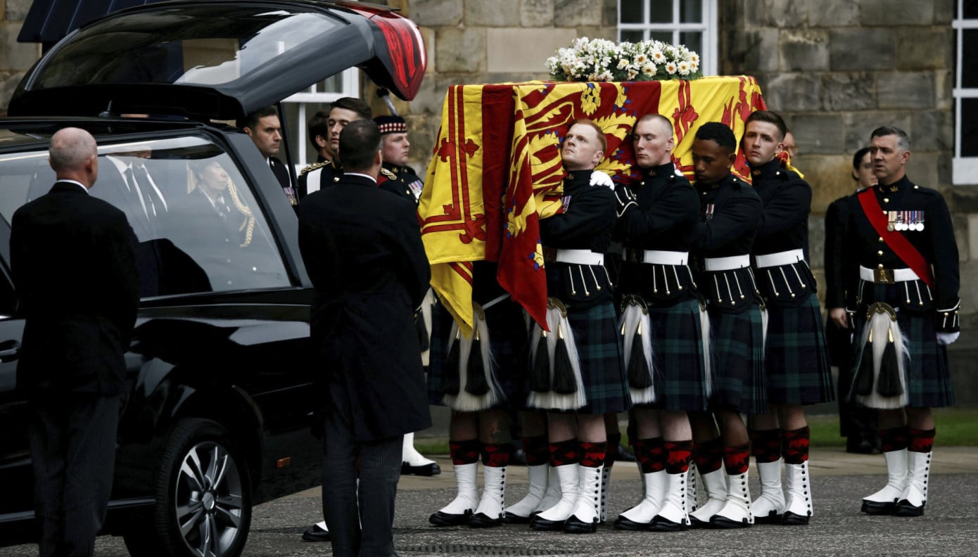 Pallbearers carry the coffin of Queen Elizabeth II, draped with the Royal Standard of Scotland, as it arrives at Holyroodhouse, where it will lie in rest for a day, in Edinburgh, Sunday, Sept. 11, 2022. Queen Elizabeth II, Britain's longest-reigning monarch and a rock of stability across much of a turbulent century, died Thursday Sept. 8, 2022, after 70 years on the throne. She was 96. (Alkis Konstantinidis/Pool Photo via AP)