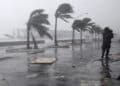 A man walks along the waterfront as Hurricane Irene passes to the east of Nassau on New Providence Island in the Bahamas, Thursday Aug. 25, 2011.  Irene is pounding the Bahamas as a Category 3 hurricane. (AP Photo/Lynne Sladky)