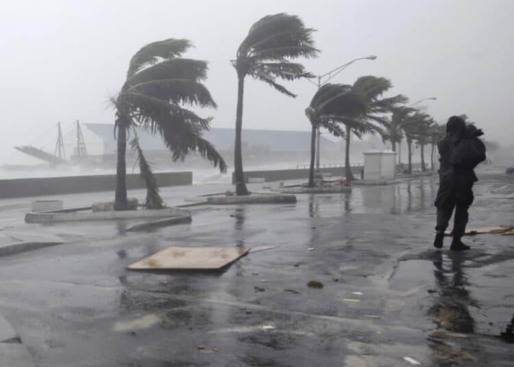 A man walks along the waterfront as Hurricane Irene passes to the east of Nassau on New Providence Island in the Bahamas, Thursday Aug. 25, 2011.  Irene is pounding the Bahamas as a Category 3 hurricane. (AP Photo/Lynne Sladky)