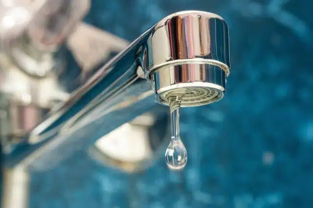 A drop of water drips from a leaky faucet.